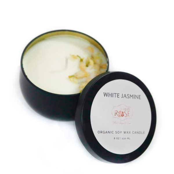 Open black candle tin with white jasmine wax and lid beside it