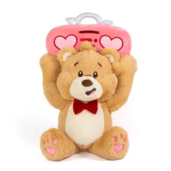 Plush tan teddy bear with red bow tie holding a pink heart radio over its head