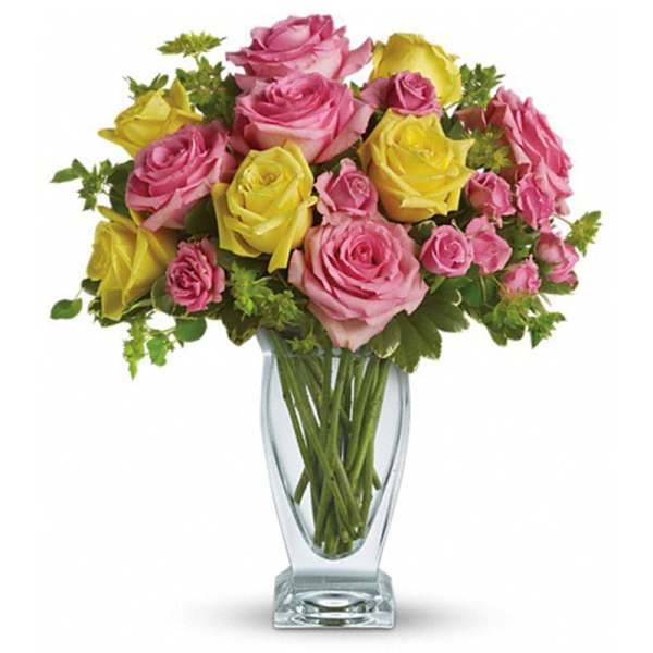 Pink and yellow roses arranged in a clear glass vase