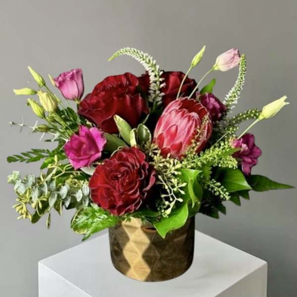 Bouquet of red and pink flowers in a gold vase