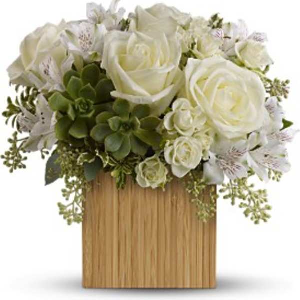 Low wooden box filled with white roses, white alstroemeria, and green succulents in a compact arrangement