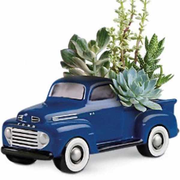 Blue pickup truck planter with succulents and greenery