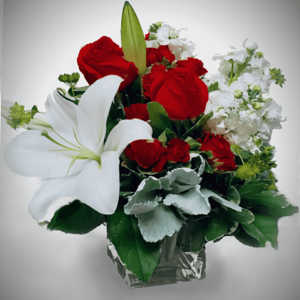 Red roses and white lilies in a clear glass vase