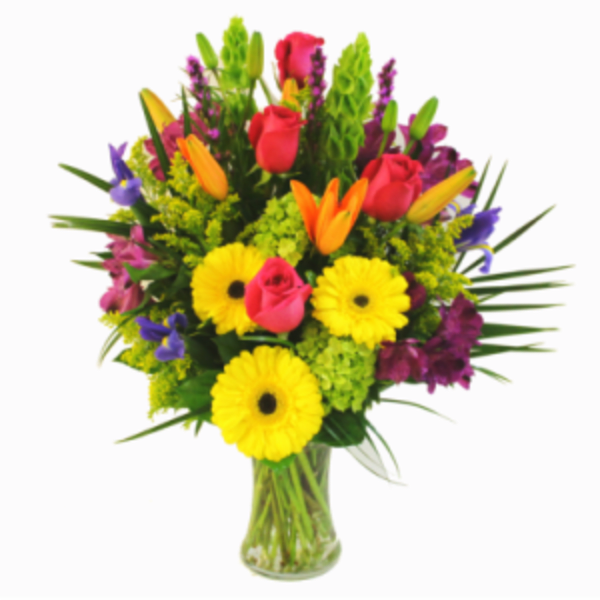 Mixed bouquet of bright flowers in a clear glass vase