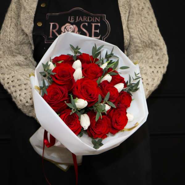 Bouquet of red roses with white buds wrapped in white paper