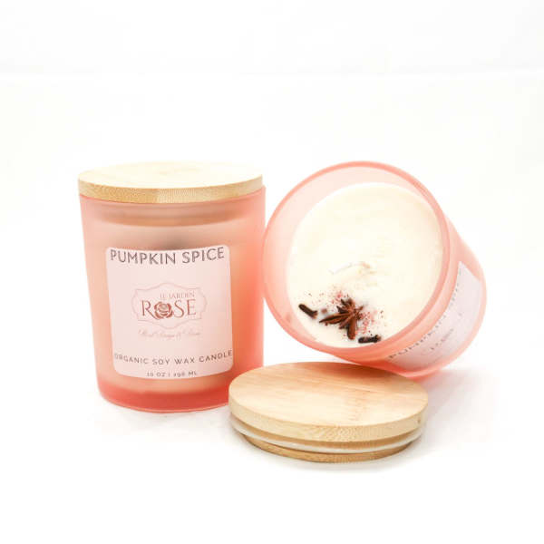 Two pumpkin spice candles in pink glass jars with bamboo lids