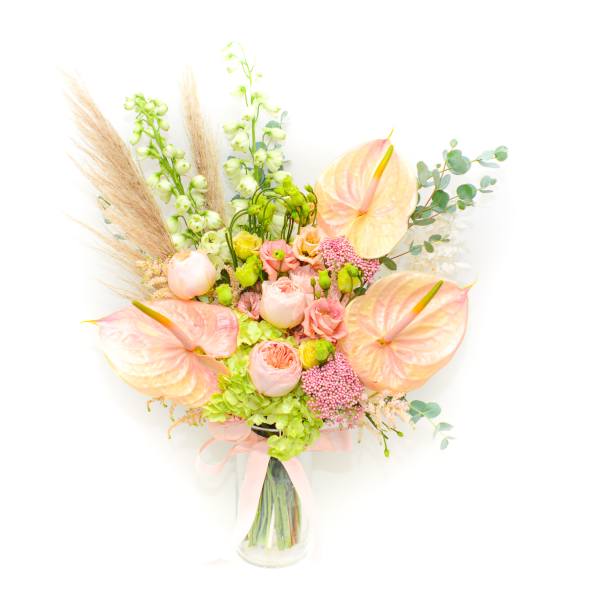 Pastel bouquet with anthuriums, roses, and tall green spikes in a glass vase