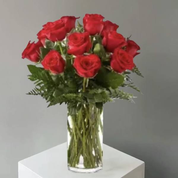 Red roses arranged in a clear glass vase