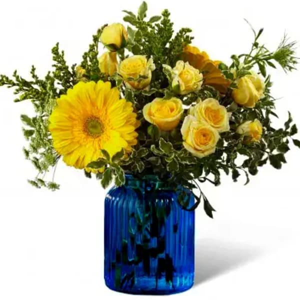 Yellow roses and a gerbera daisy in a blue glass vase