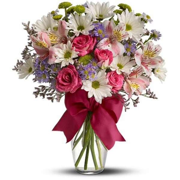 Bouquet of pink roses, white daisies, and alstroemeria in a glass vase with a red ribbon