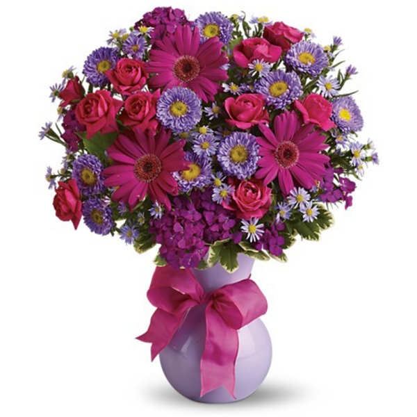 Bouquet of pink and purple flowers in a lavender vase with a ribbon