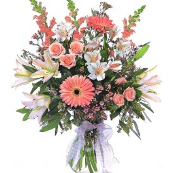 Mixed bouquet of pink and white flowers in a glass vase with a ribbon