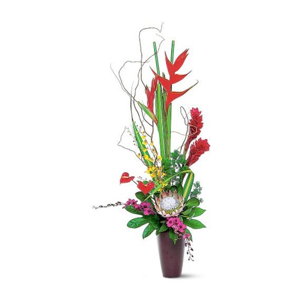 Tall tropical flower arrangement in a dark vase with red and pink blooms