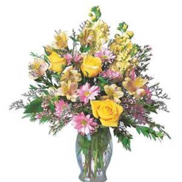 Mixed bouquet of yellow roses and pink daisies in a glass vase