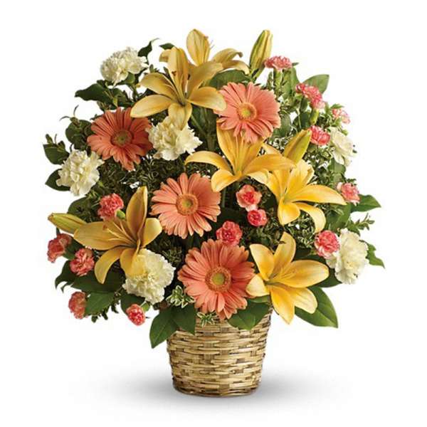 Yellow lilies, peach gerbera daisies, and carnations arranged in a woven basket.