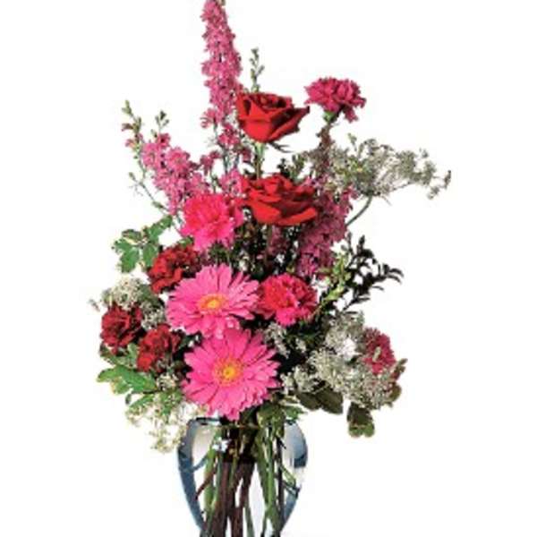 Tall bouquet of pink and red flowers in a clear glass vase
