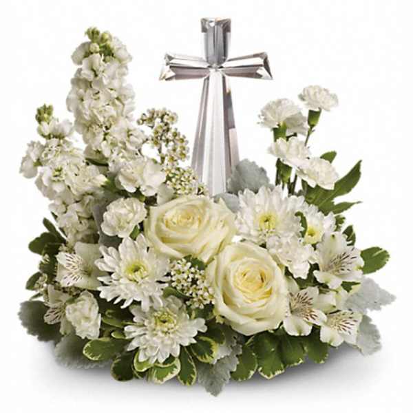White floral arrangement with roses and mums surrounding a clear crystal cross.