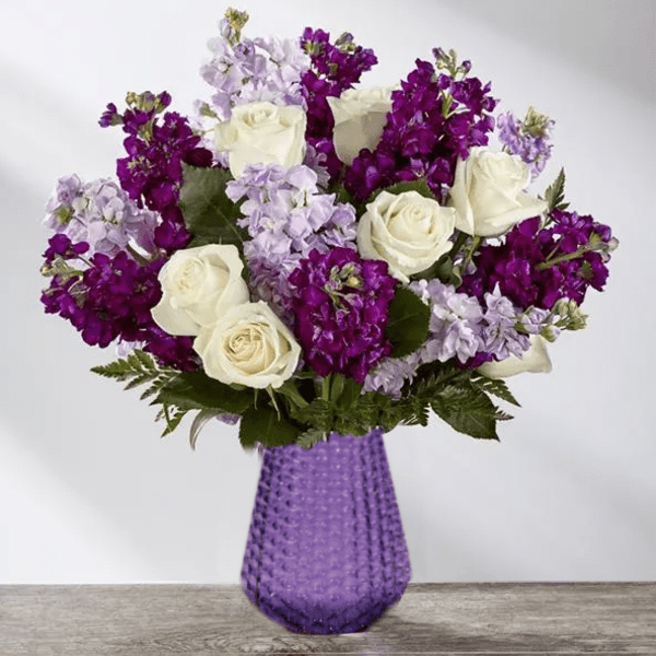 Purple and white roses in a textured purple vase
