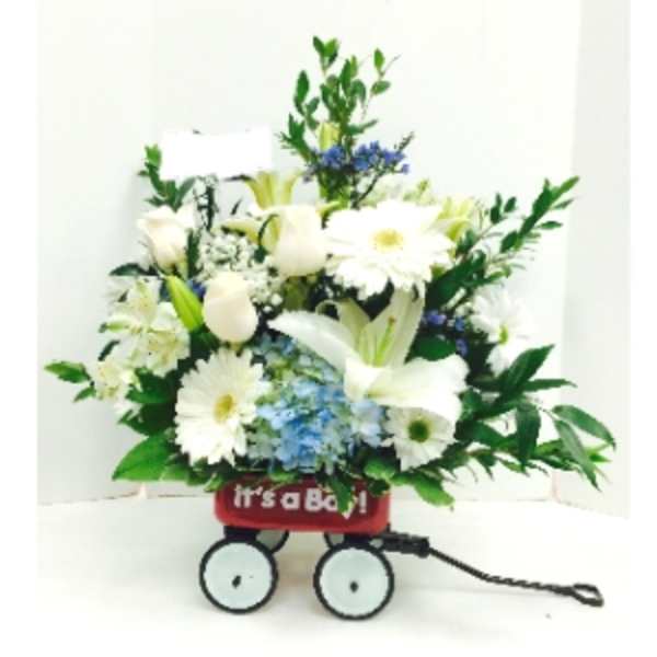 White floral arrangement in a red wagon with wheels