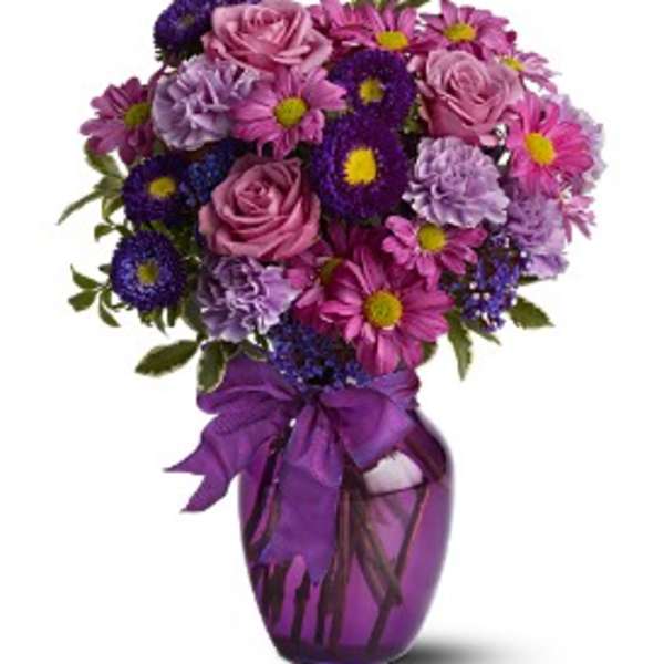 Purple and pink bouquet in a purple vase with a ribbon
