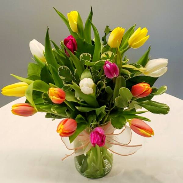 Bouquet of multicolored tulips in a clear glass vase