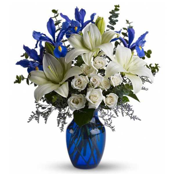 White lilies and roses with blue irises in a blue vase