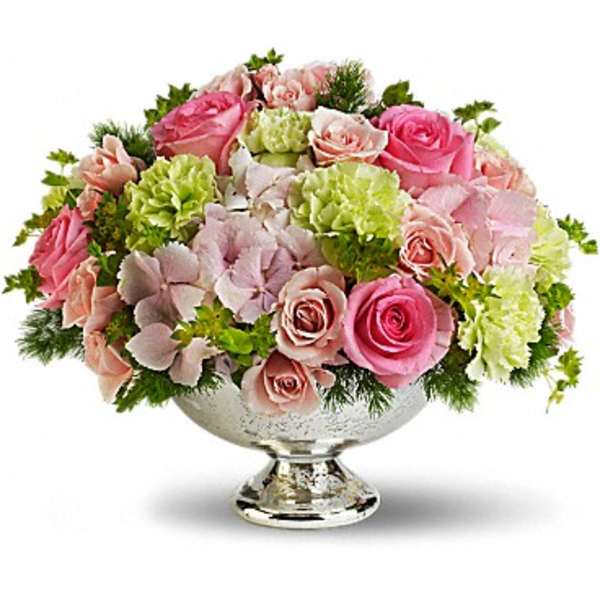 Pink and pale green floral arrangement in a silver pedestal vase