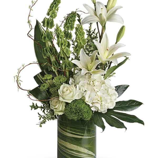 White lilies and roses arranged in a green glass vase