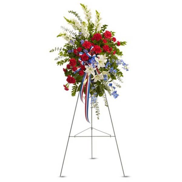Tall red, white, and blue standing spray with lilies and carnations on a metal easel