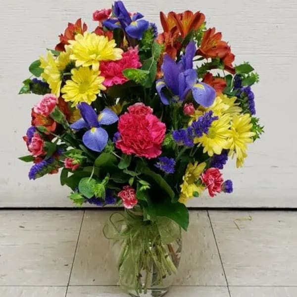 Mixed bouquet of bright flowers in a clear glass vase