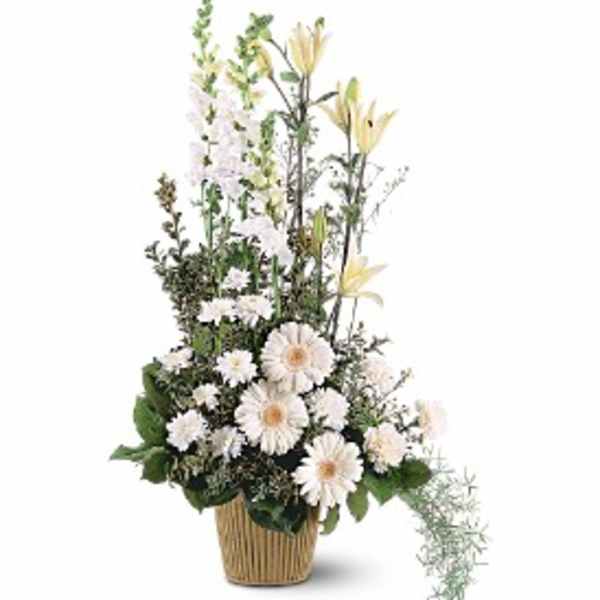 Tall white and cream floral arrangement with lilies and gerbera daisies in a woven basket