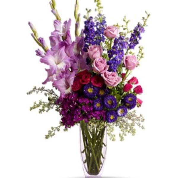 Purple and pink mixed flower arrangement in a clear vase