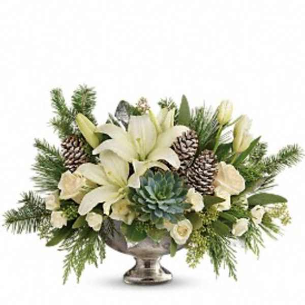 White lilies and pinecones arranged in a silver pedestal vase