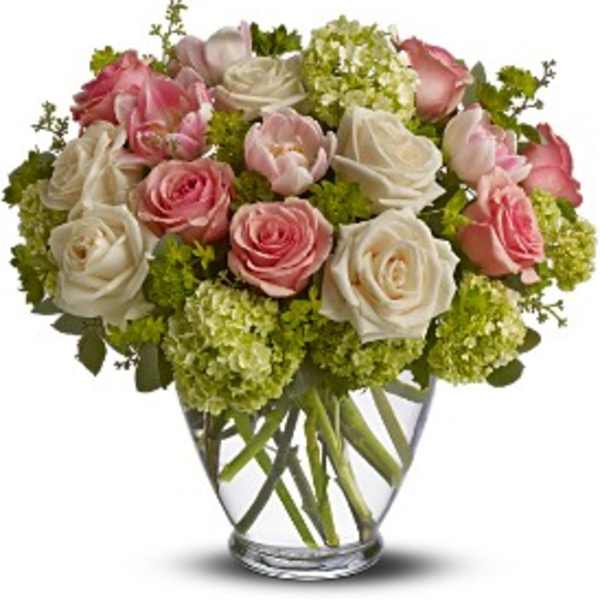 Pink and white roses arranged in a clear glass vase