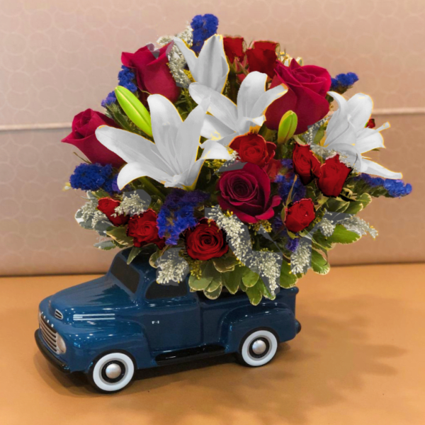 Bouquet of red roses and white lilies in a blue truck container