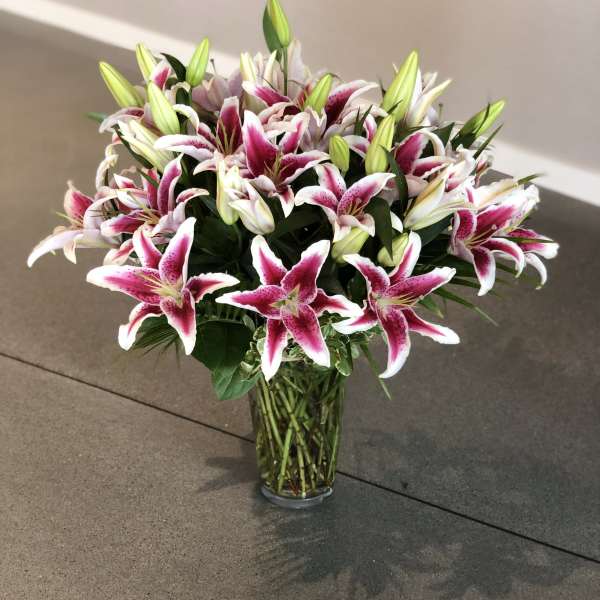 Bouquet of pink and white lilies in a clear glass vase