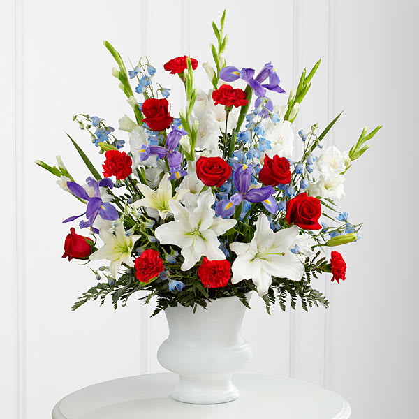 Bouquet of red roses, white lilies, and purple iris in a white vase