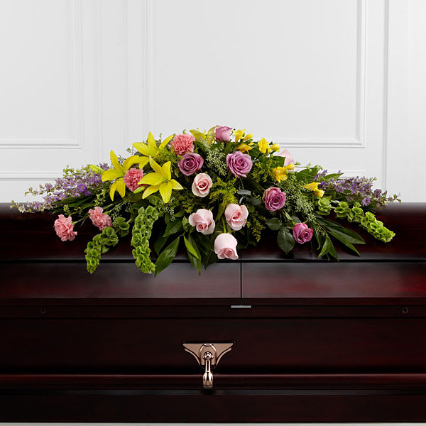Casket spray with pink and yellow flowers