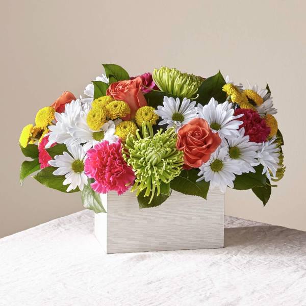 Mixed bouquet of daisies, roses, and carnations in a white box