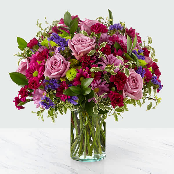 Pink and purple mixed bouquet in a clear glass vase