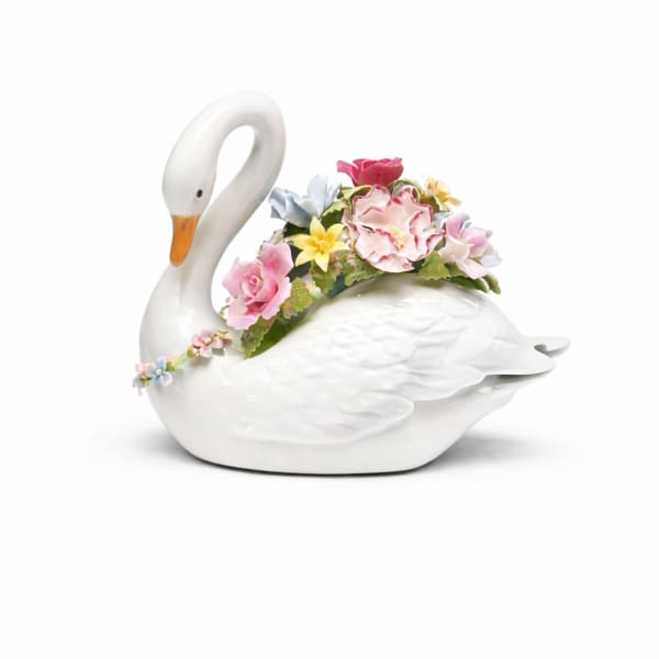 White ceramic swan figurine decorated with pastel sculpted flowers on its back and neck.