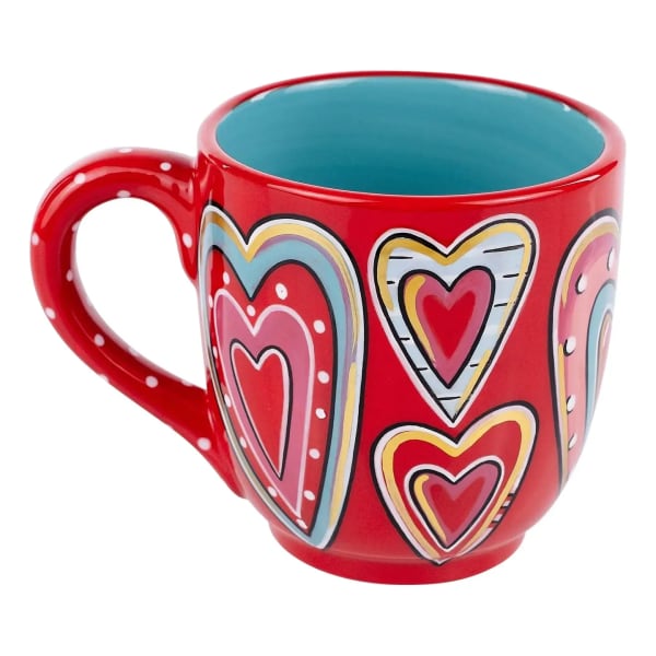 Red ceramic mug with colorful heart patterns and teal interior