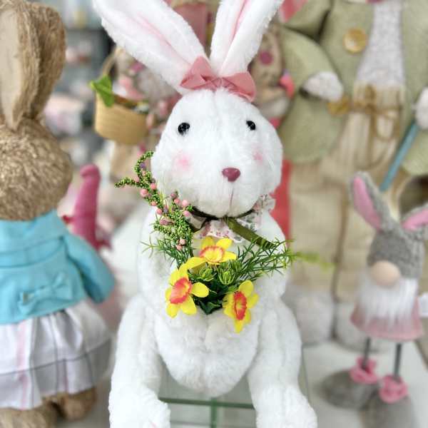 White plush bunny holding a small yellow flower bouquet