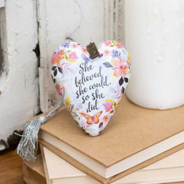 Heart-shaped floral decorative pillow with a quote printed on it