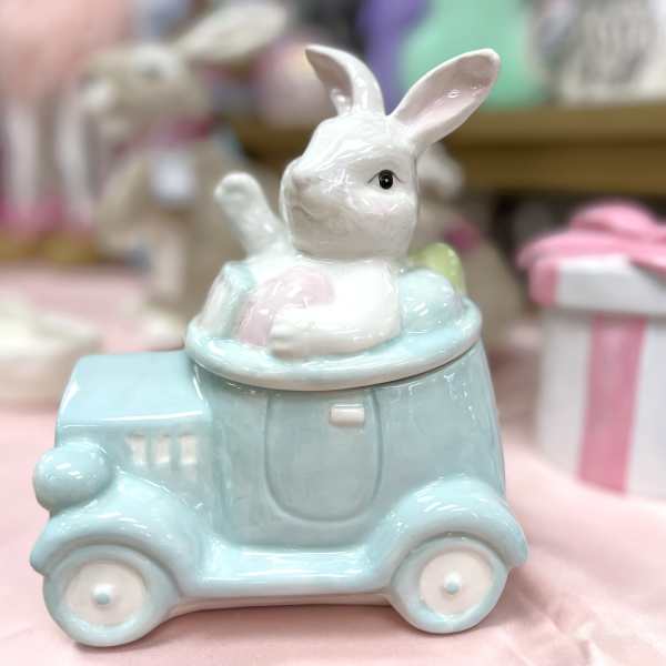Ceramic bunny figurine sitting in a pastel blue vehicle-shaped container