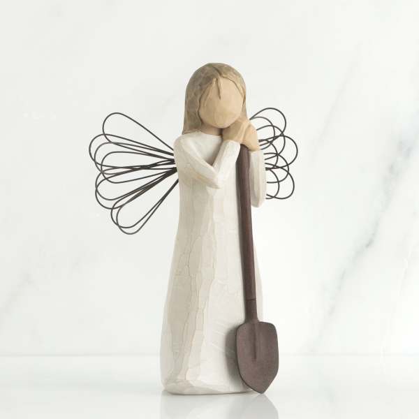 Wooden angel figurine holding a shovel
