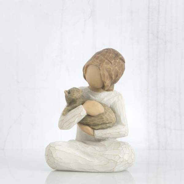 Wooden figurine of a seated person holding a cat