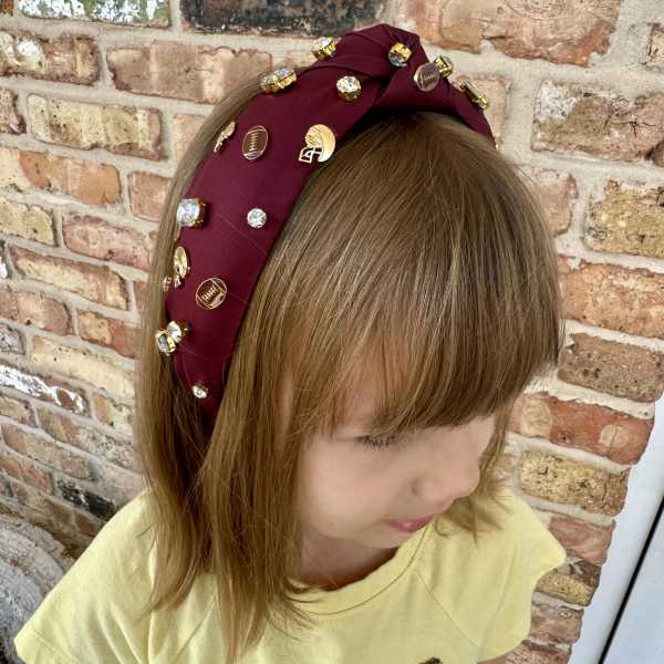Child wearing a burgundy jeweled headband