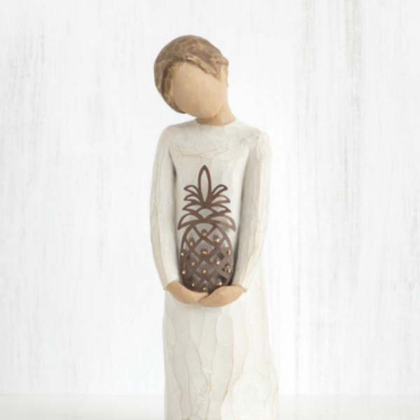 Carved figurine of a person holding a pineapple