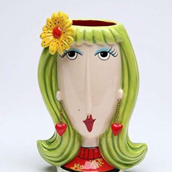 Decorative ceramic vase shaped like a woman's face with a flower accent